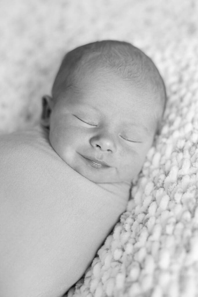 A sweet newborn baby smiling while sleeping.
