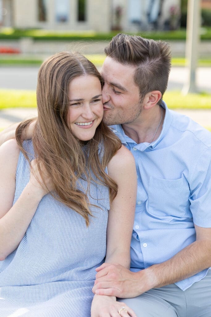 Man kissing his new fiance's cheek during a photo session.