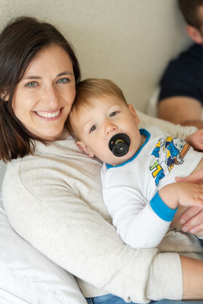 Mother and son smiling and looking at the camera during an at home session. 