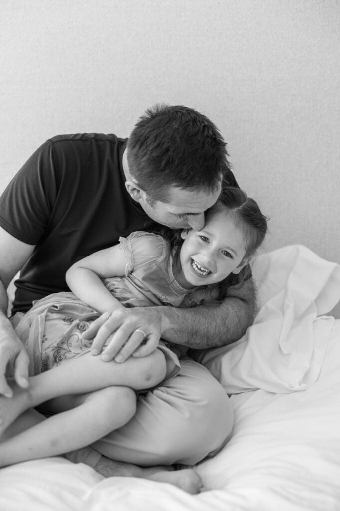 Father and young daughter laughing and playing together.  
