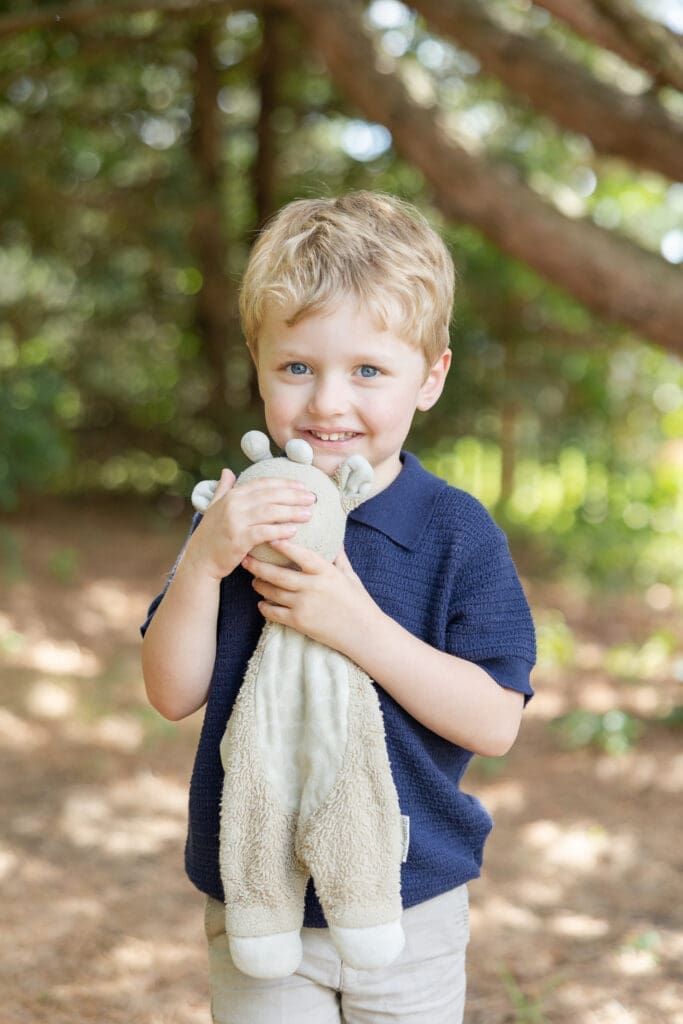 Big brother holding his favorite stuffed animal during a family photography session.