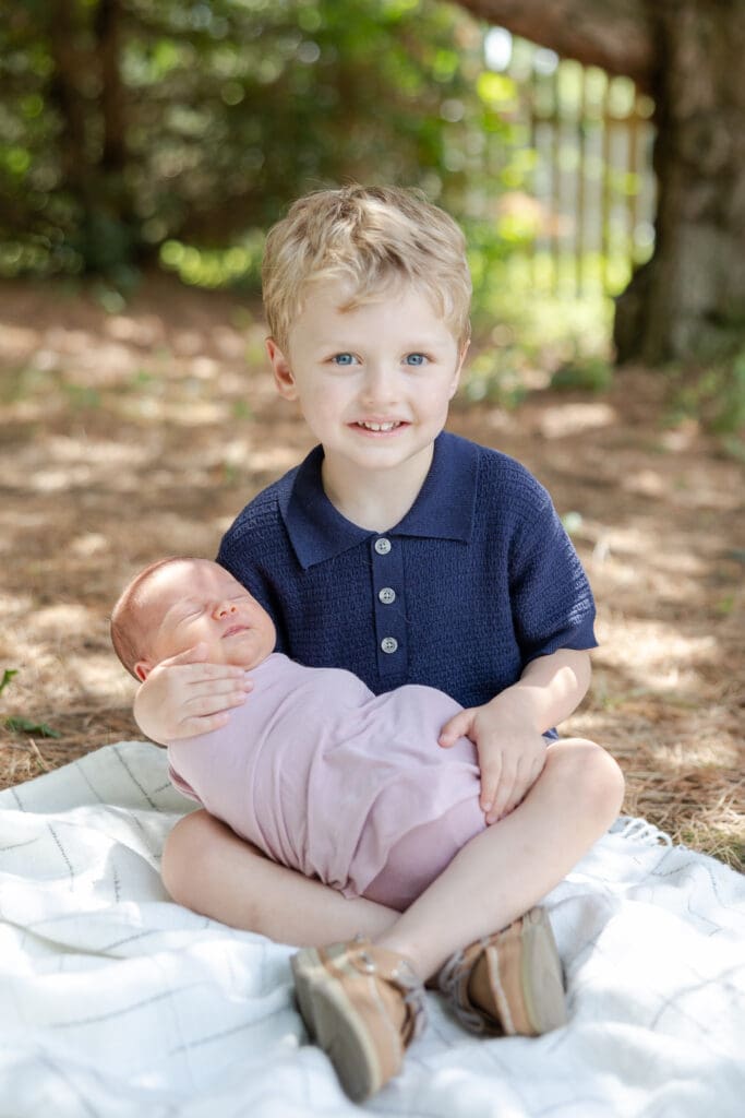 Big brother holding new baby sister outside in Milwaukee