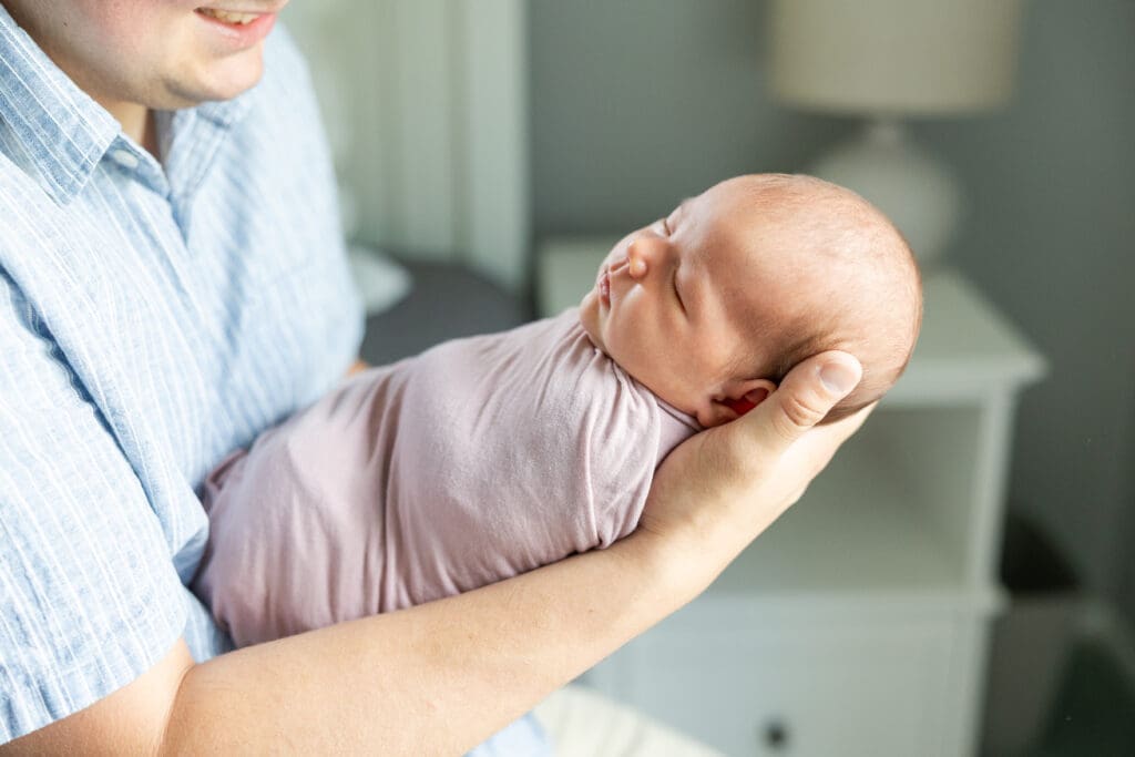 A father holding his newborn daughter at their home in Milwaukee.