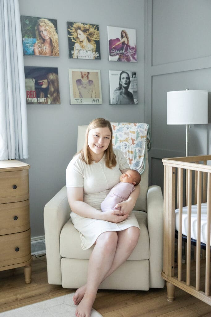 A new mother holding her infant daughter in her Taylor Swift inspired nursery in Milwaukee.