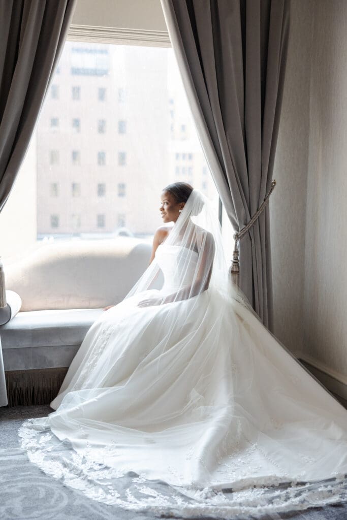 Bride looking out the window of The Pfister Hotel on her wedding day. 