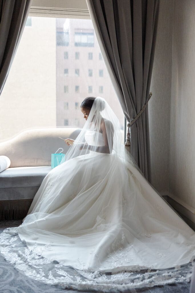 Bride reading a card and opening a Tiffany's present that her Groom sent her on her wedding day.
