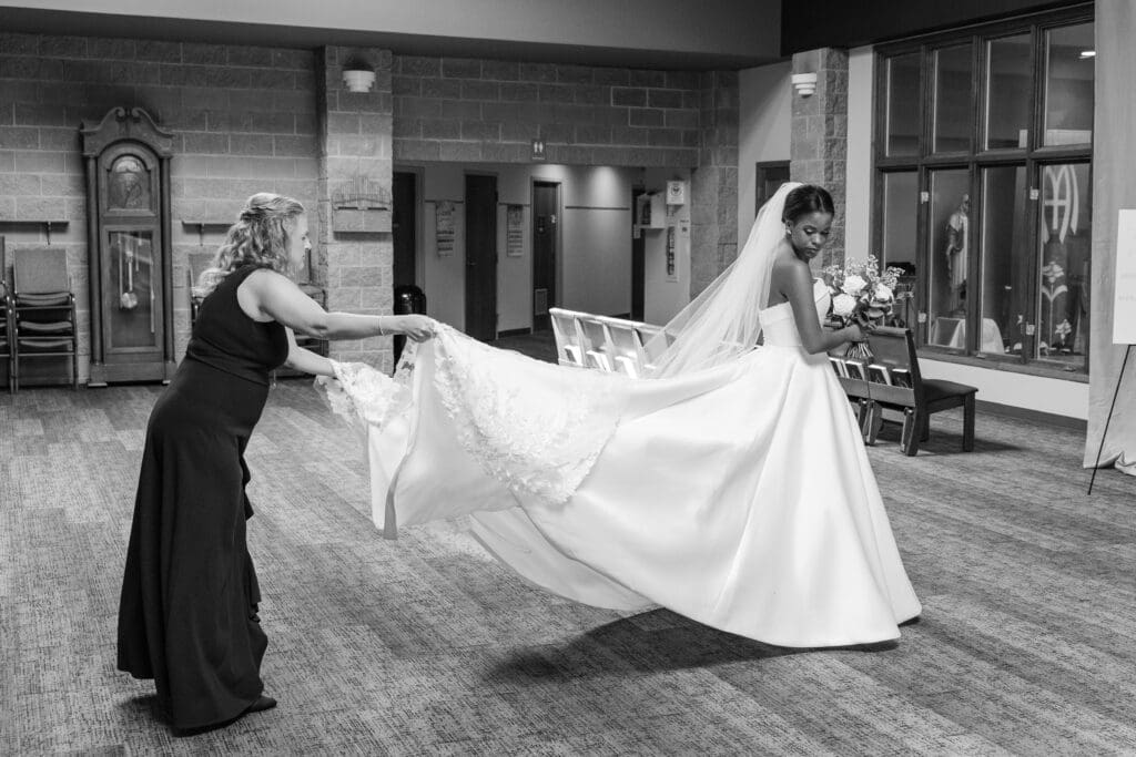 Bride getting her dress train all straightened out before she walks down the isle. 