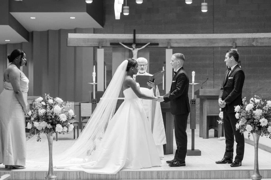 Bride and Groom holding hands as they exchange vows at their Pfister Hotel Wedding in Milwaukee.  