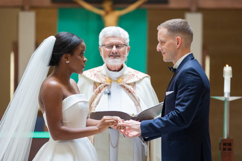 Bride putting on the Groom's rings while exchanging of the rings at the ceremony. 