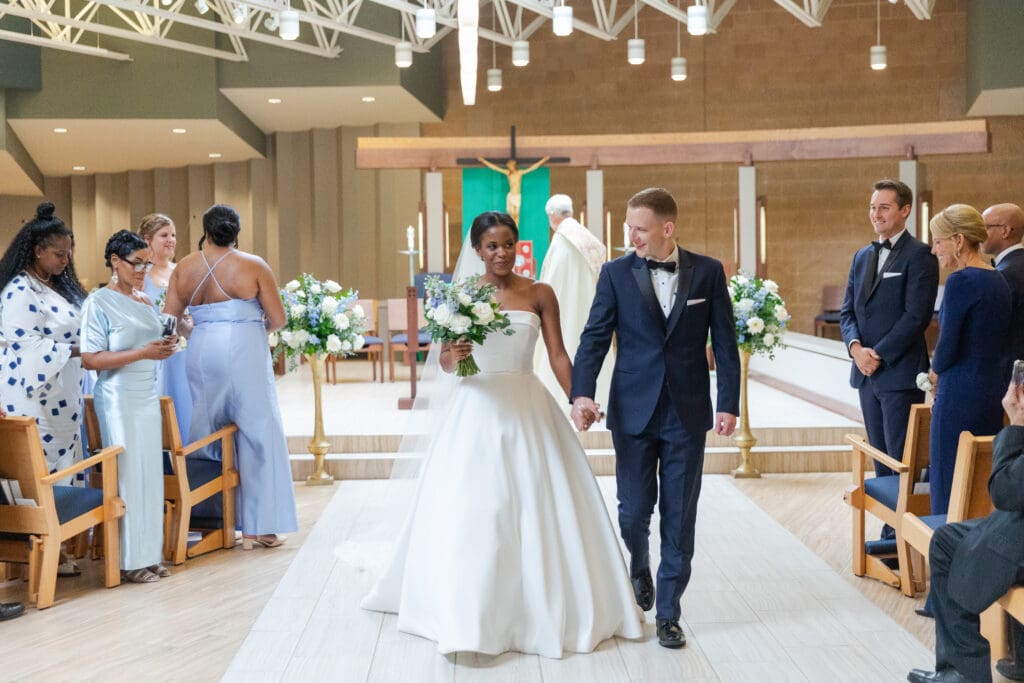Bride and groom smiling as they leave the ceremony.  