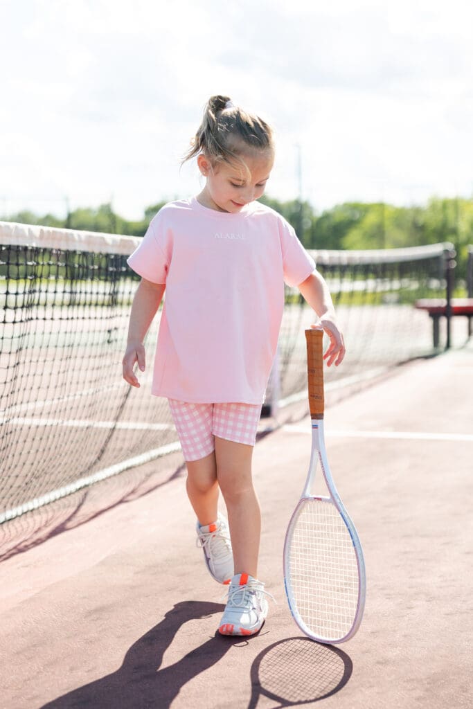 Girl twirling a tennis racket on the court