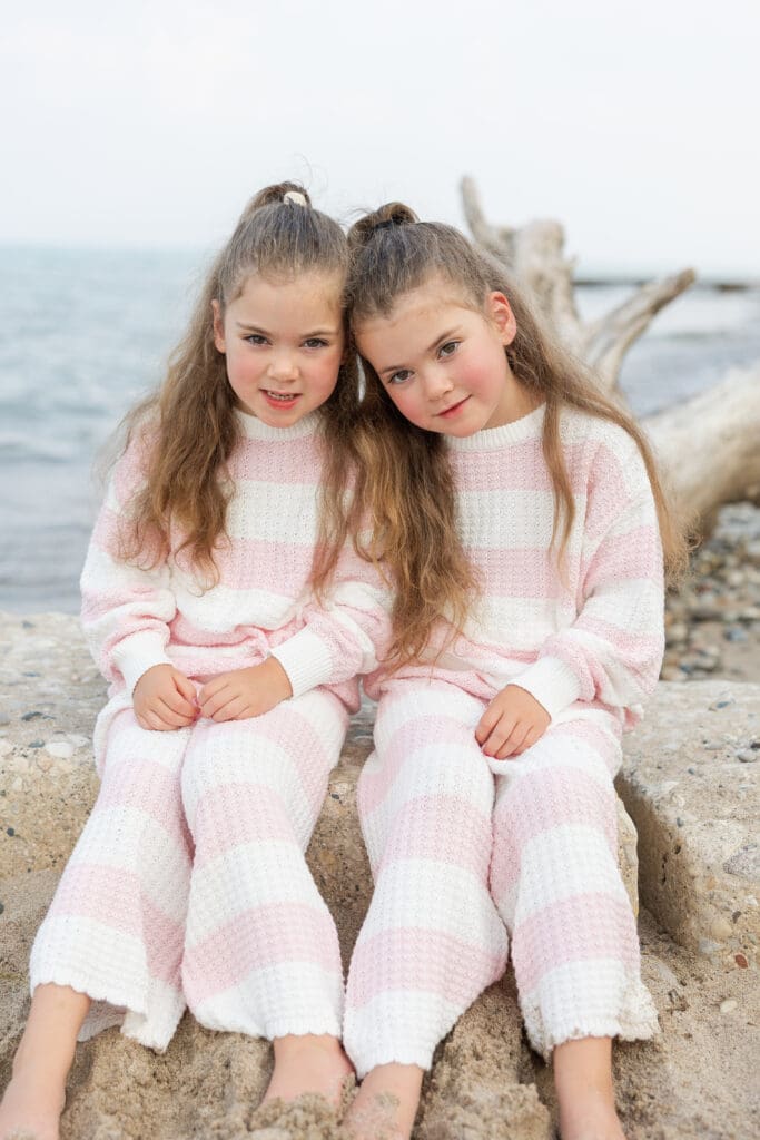 Girls sitting on a log in cute cloths being sold on Alarae Kids Clothing website