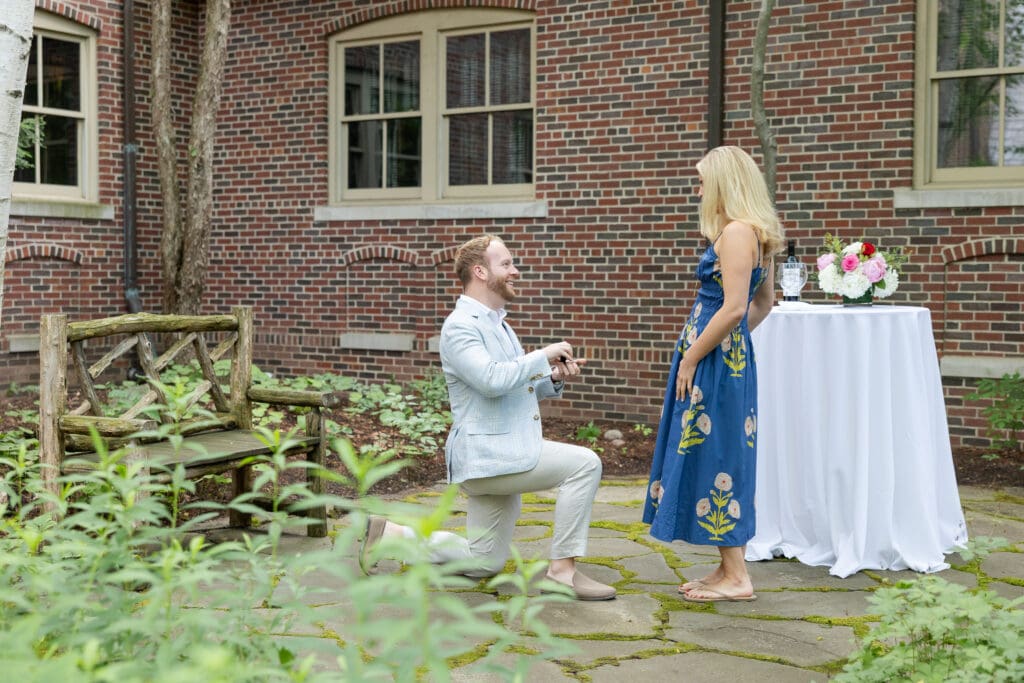 Man on one knee proposing to his girlfriend.