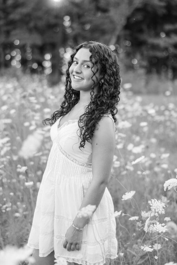 Black and white image of a young lady in a field of flowers at the Mequon Nature Preserve.