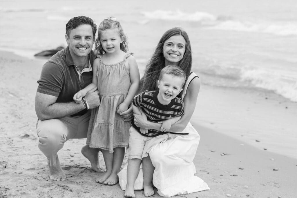 Lake Michigan family photography session on the beach, family of four smiling at the camera. 
