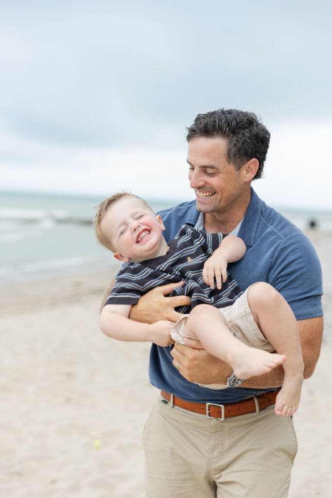 A father holding his young son smiling and laughing together. 