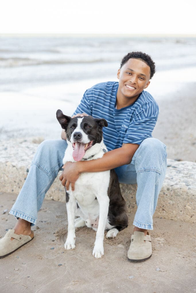 Senior in highschool on the beach with his dog during a senior photo session with Milwaukee Photo Company 