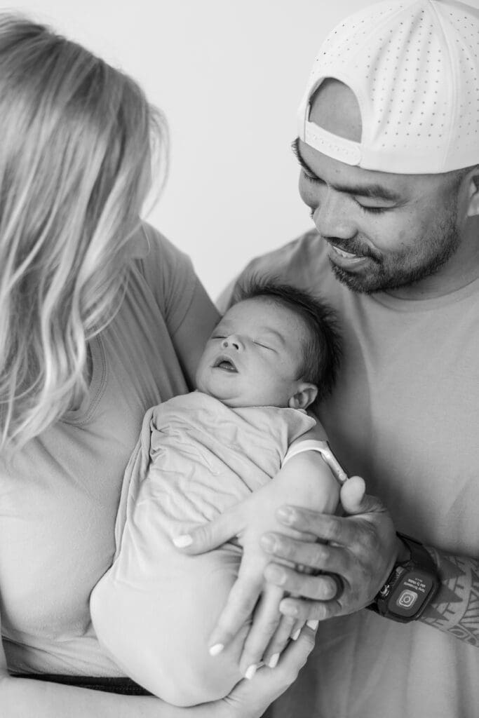Mom and dad holding sweetly newborn baby during a family session in Milwaukee 