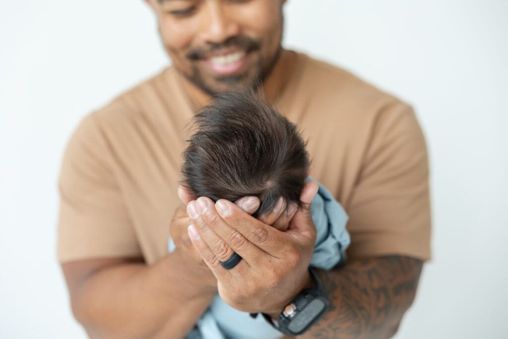 Milwaukee newborn photographer capturing baby Oliver with dad